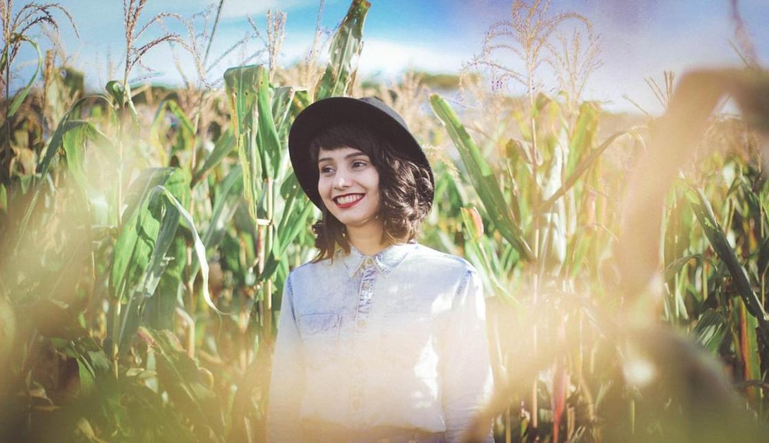 Девушка стоит в пшеничном поле