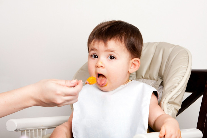 Ребенок ест фруктовое пюре